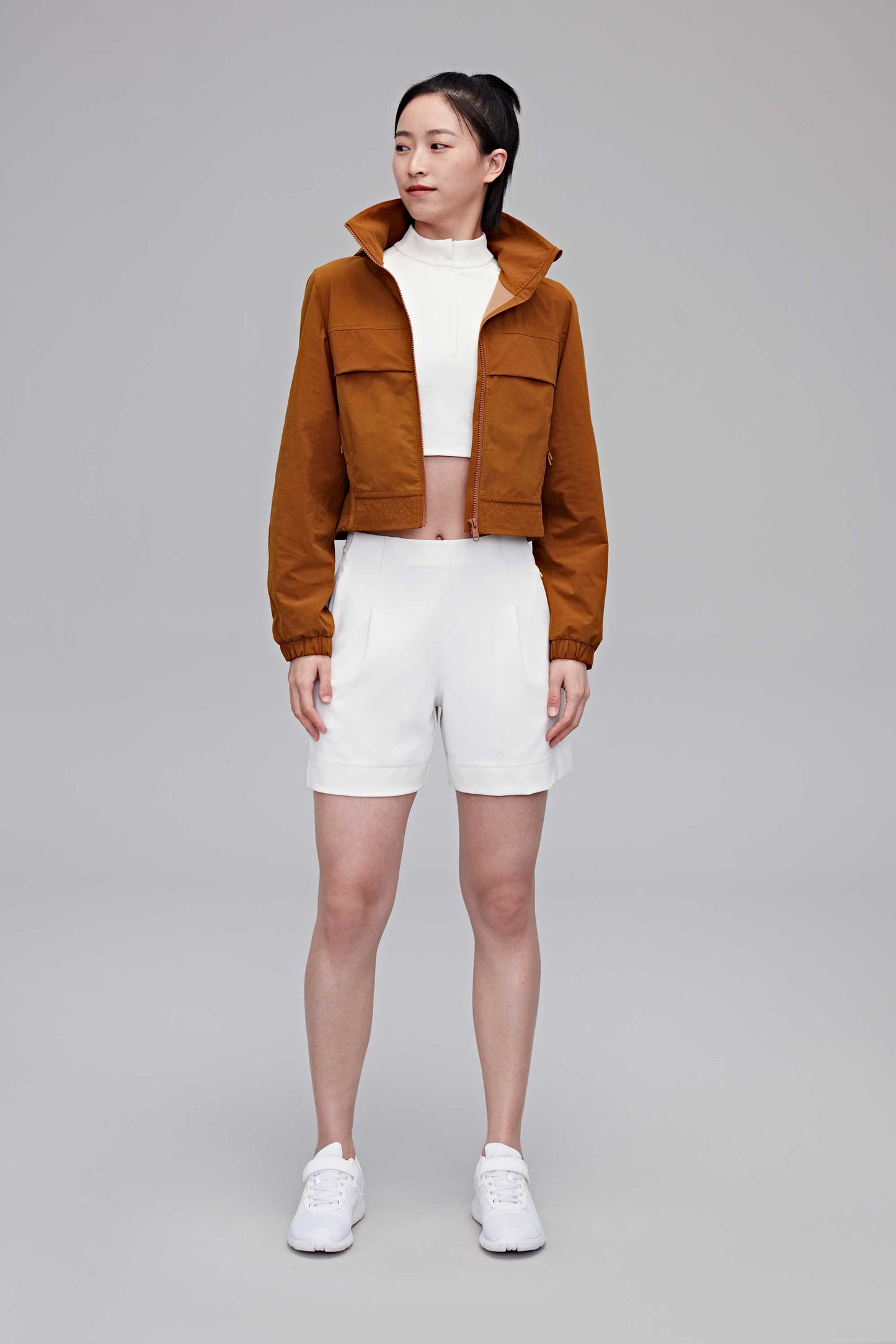 woman in brown jacket and white shorts