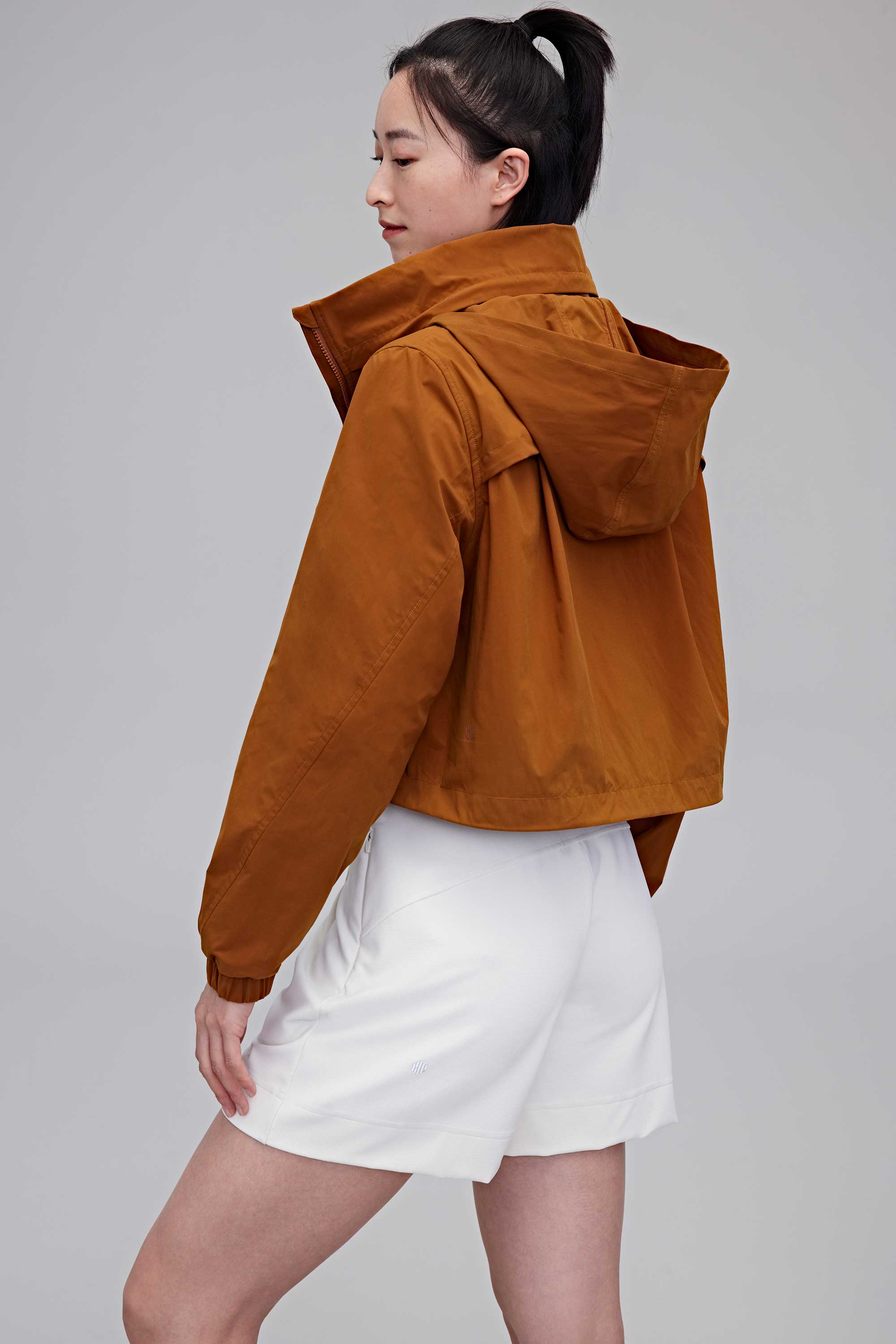 woman in brown jacket and white shorts