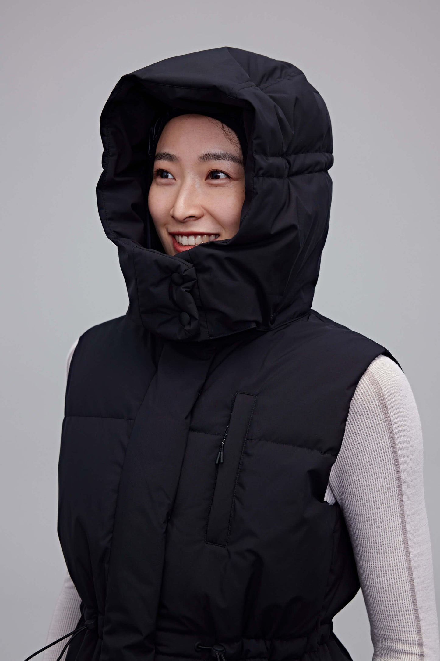 woman in black hooded down vest wearing the hood