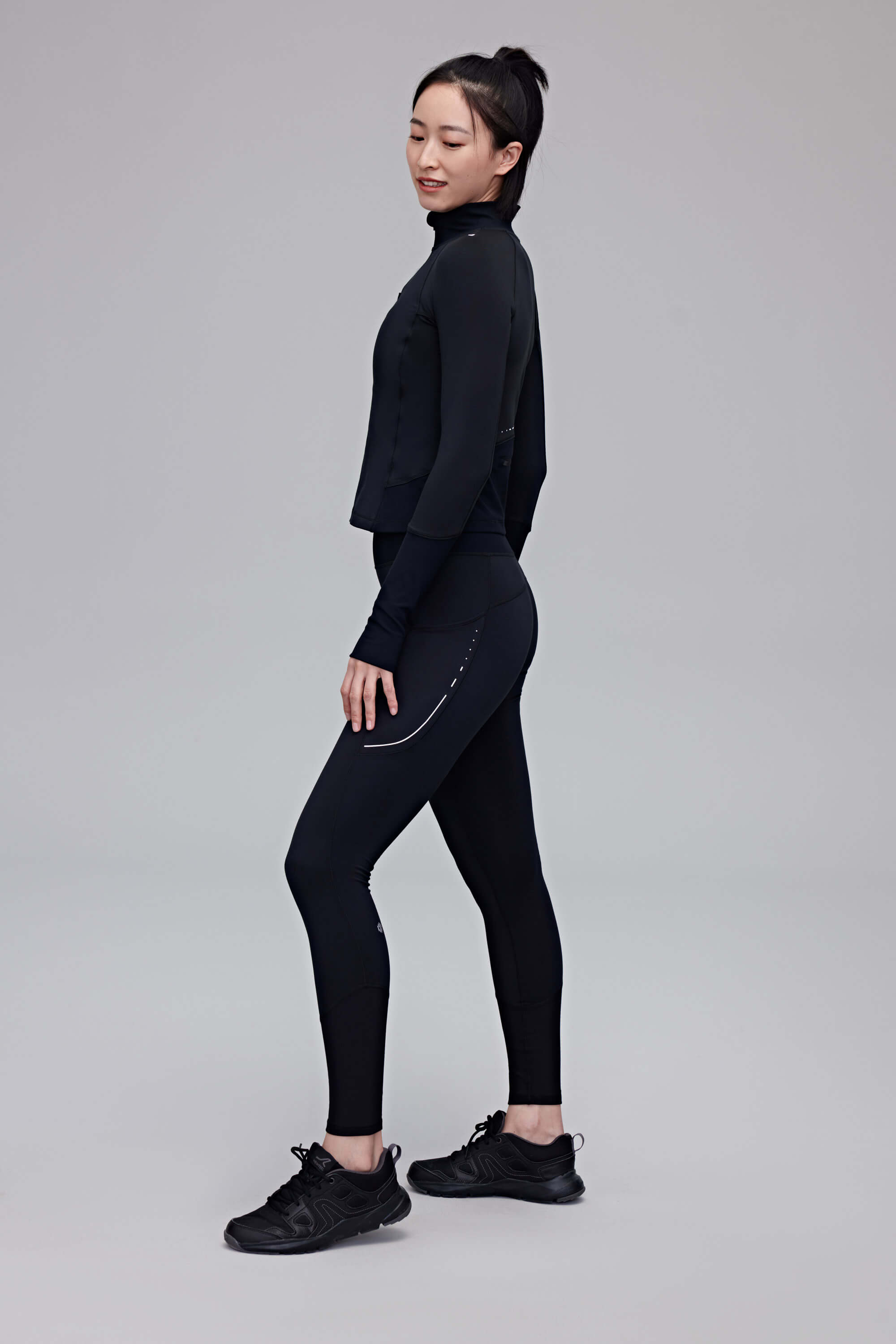 side of woman in black top and leggings
