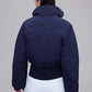 back of woman in navy down jacket