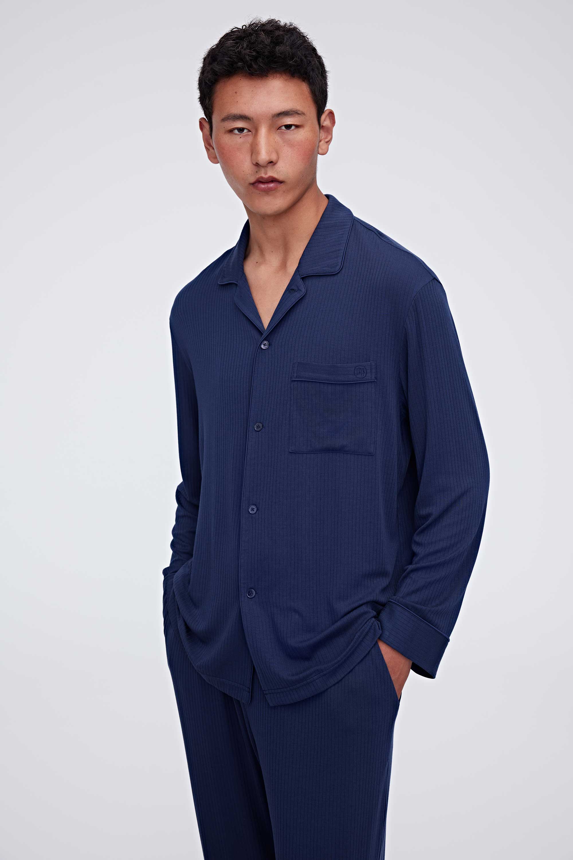 man in navy pajama button up shirt and pants