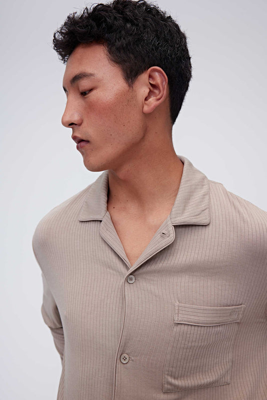 close up of man in tan pajama button up shirt