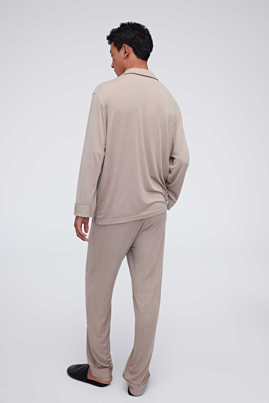 back of man in tan pajama button up shirt and pants