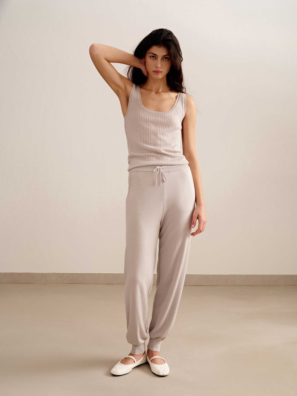 woman in light pink tank top and joggers