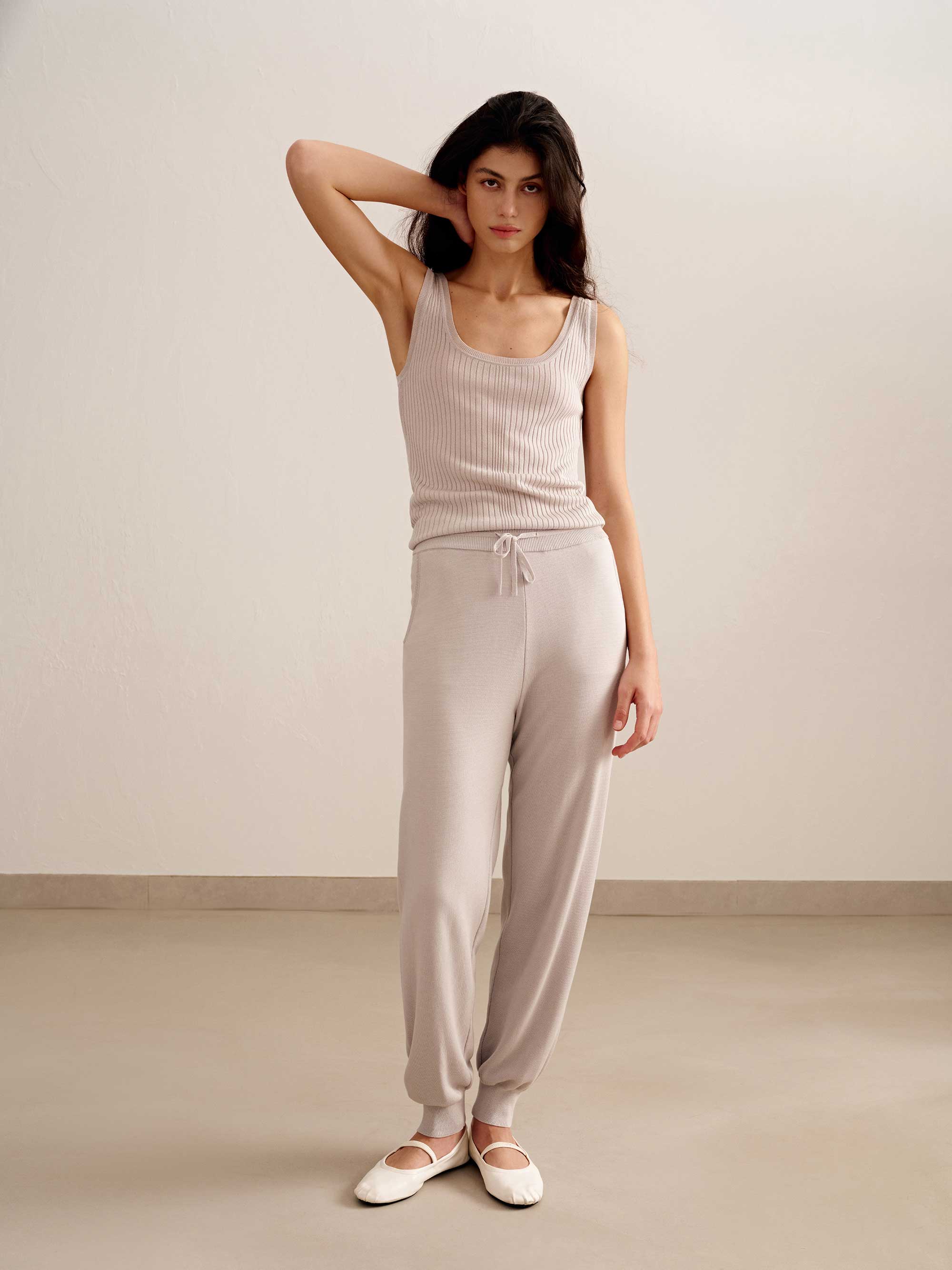 woman in light pink tank top and joggers