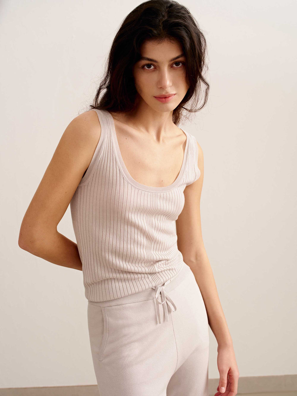 woman in light pink tank top and joggers