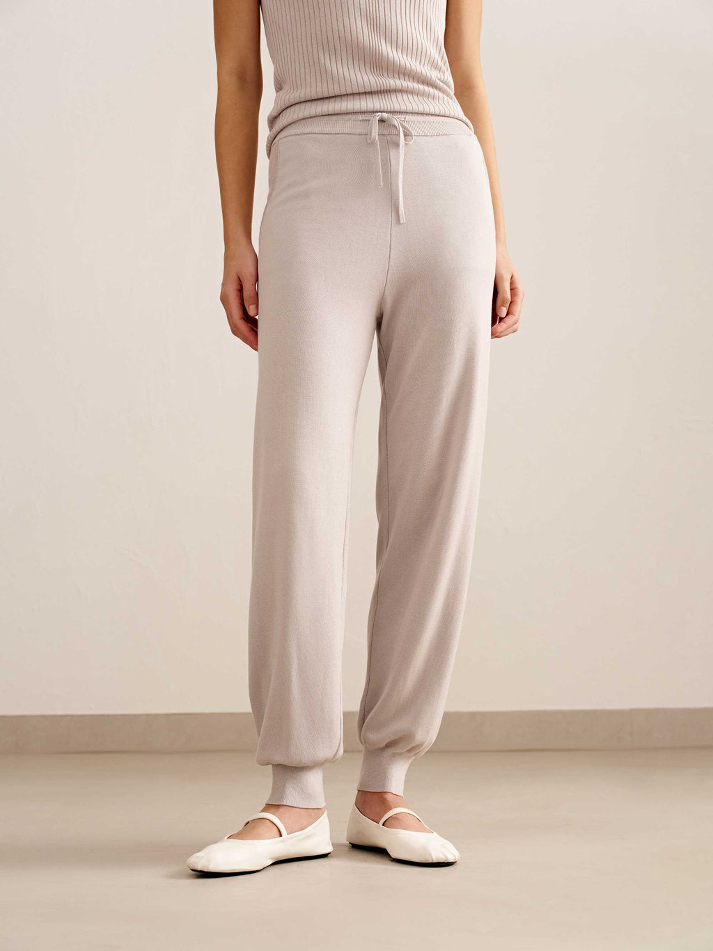 woman in light pink tank top and joggers