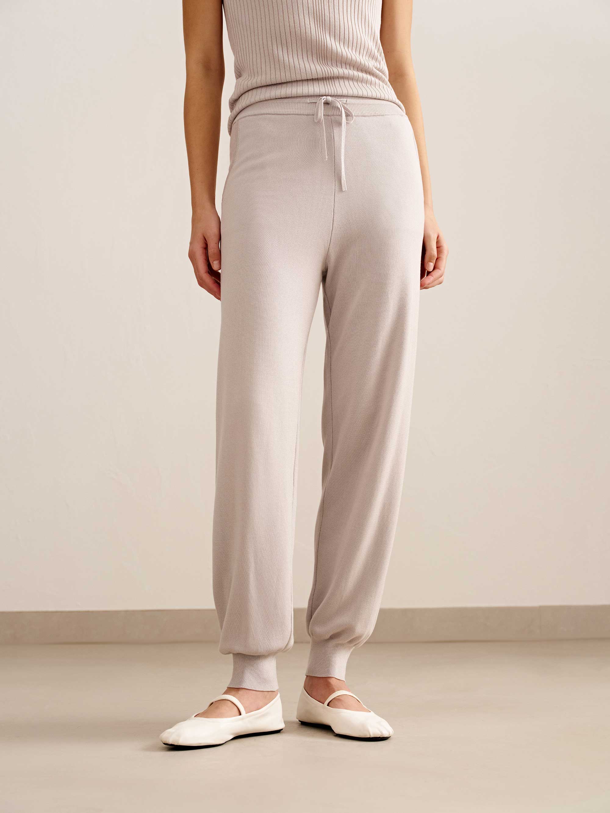 woman in light pink tank top and joggers