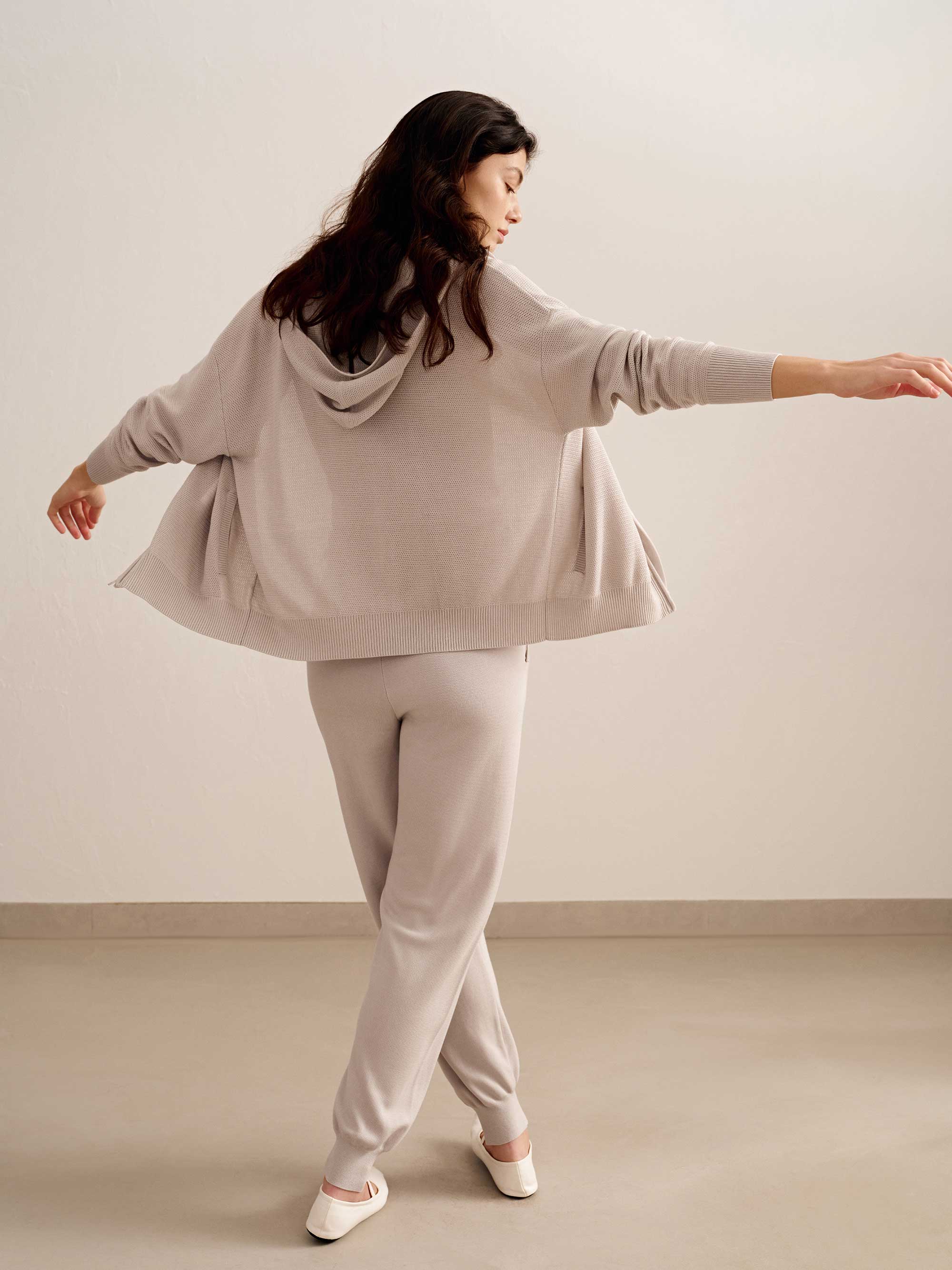 back of woman in light pink hoodie and joggers