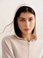 close up of woman in light pink hoodie