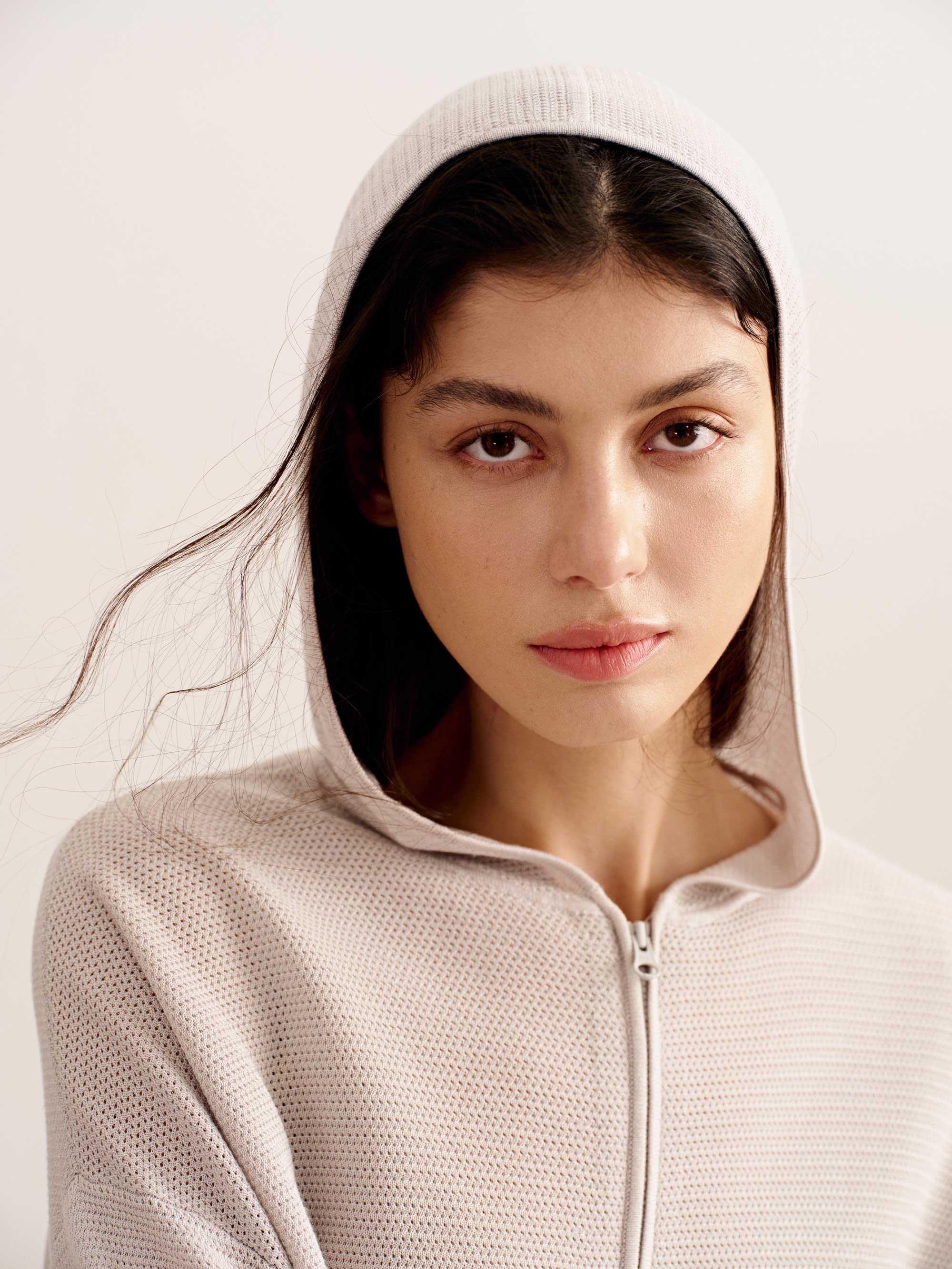 close up of woman in light pink hoodie