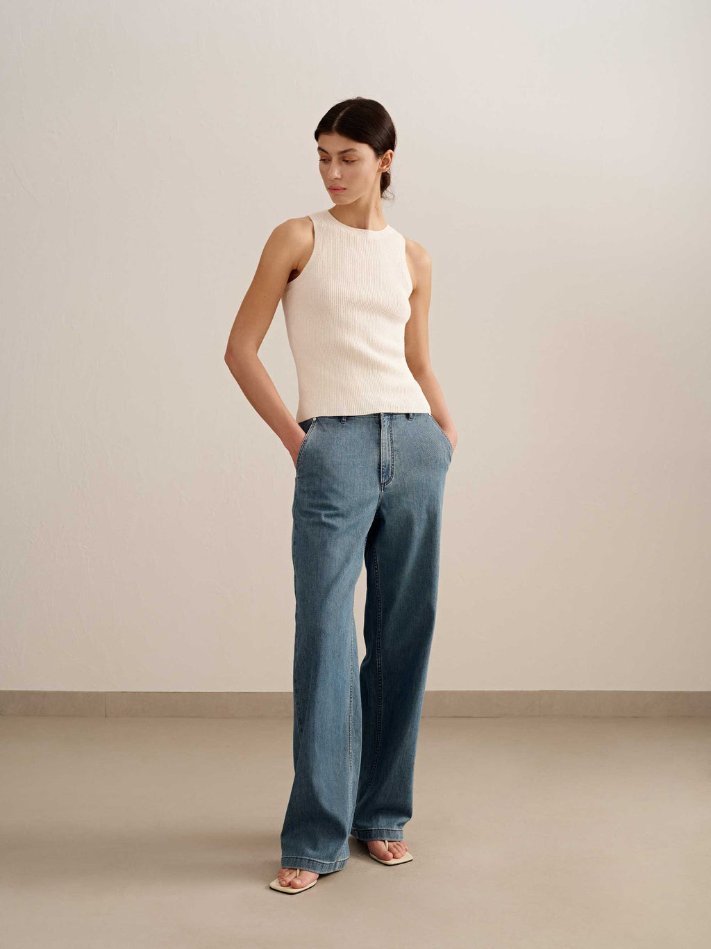 woman wearing a white tank and blue jeans