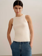 woman wearing a white tank and blue jeans