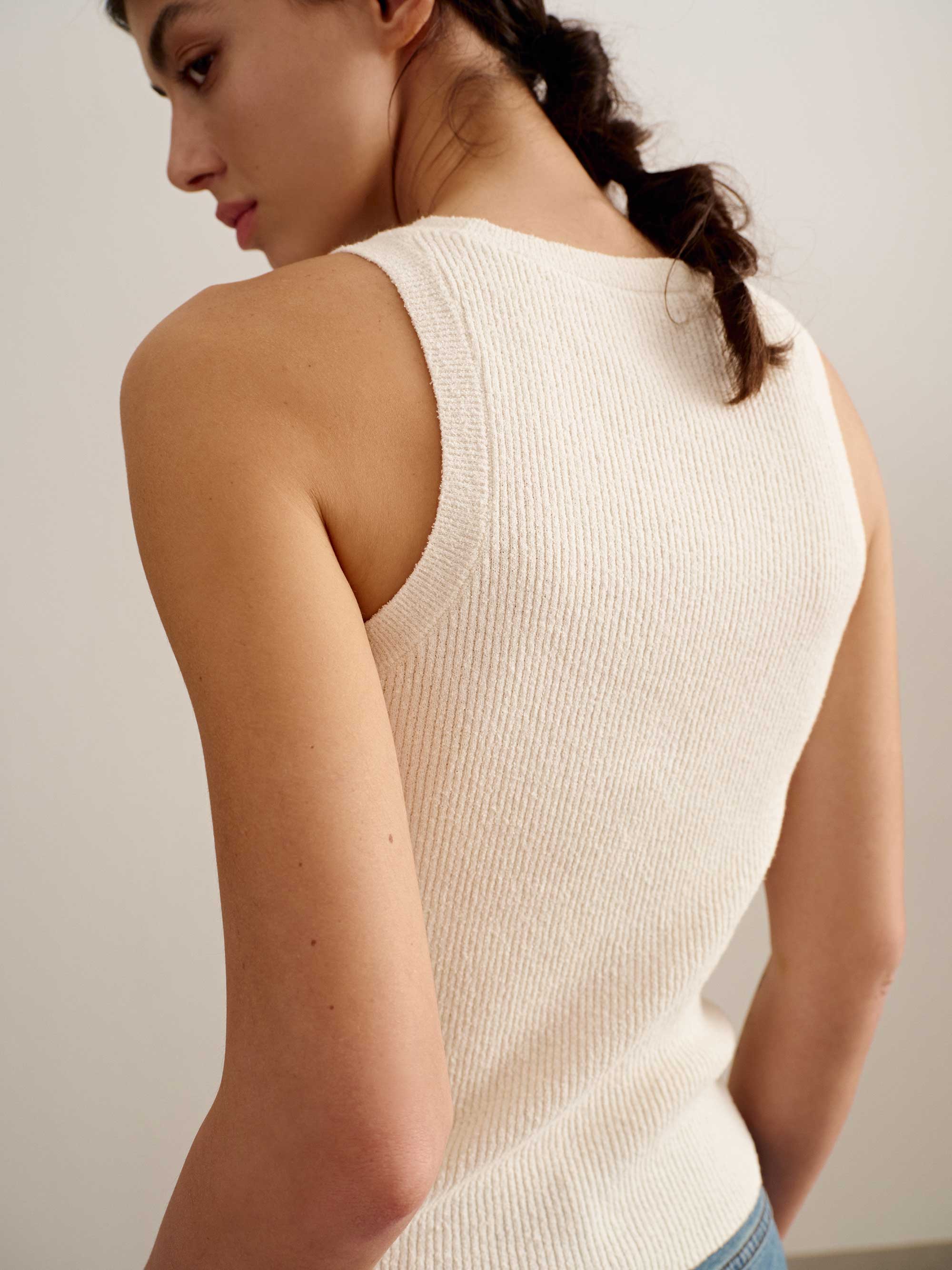 back of a woman wearing a white tank