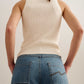 back of a woman wearing a white tank and blue jeans
