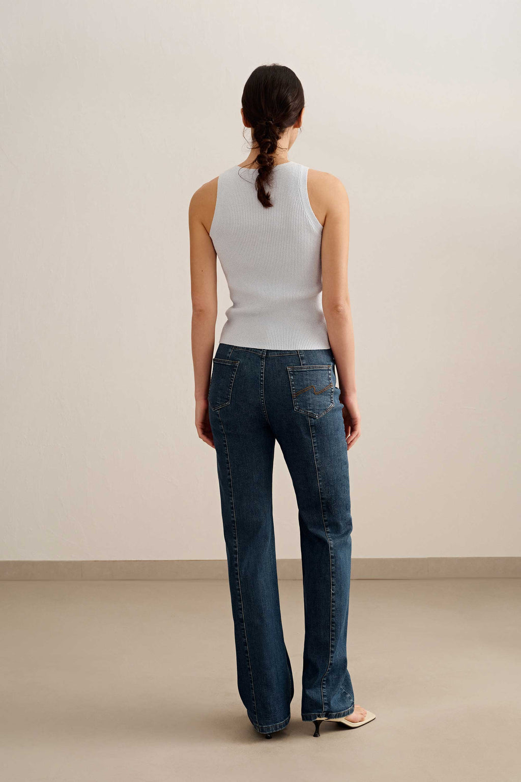 back of a woman wearing a blue tank and blue jeans