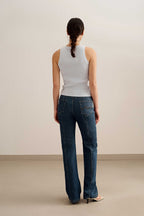 back of a woman wearing a blue tank and blue jeans
