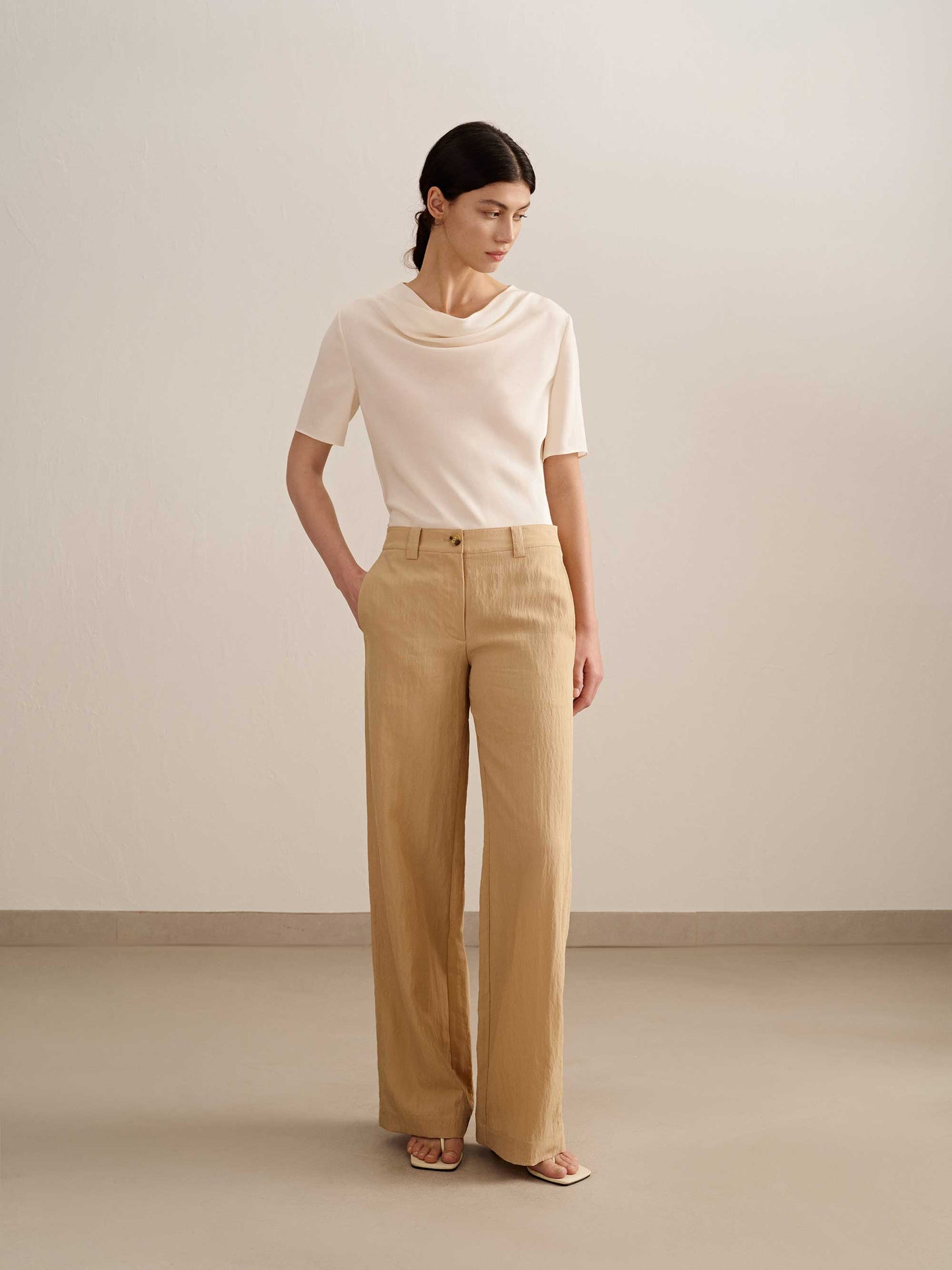 a woman wearing a yellow wide leg trousers with white tee