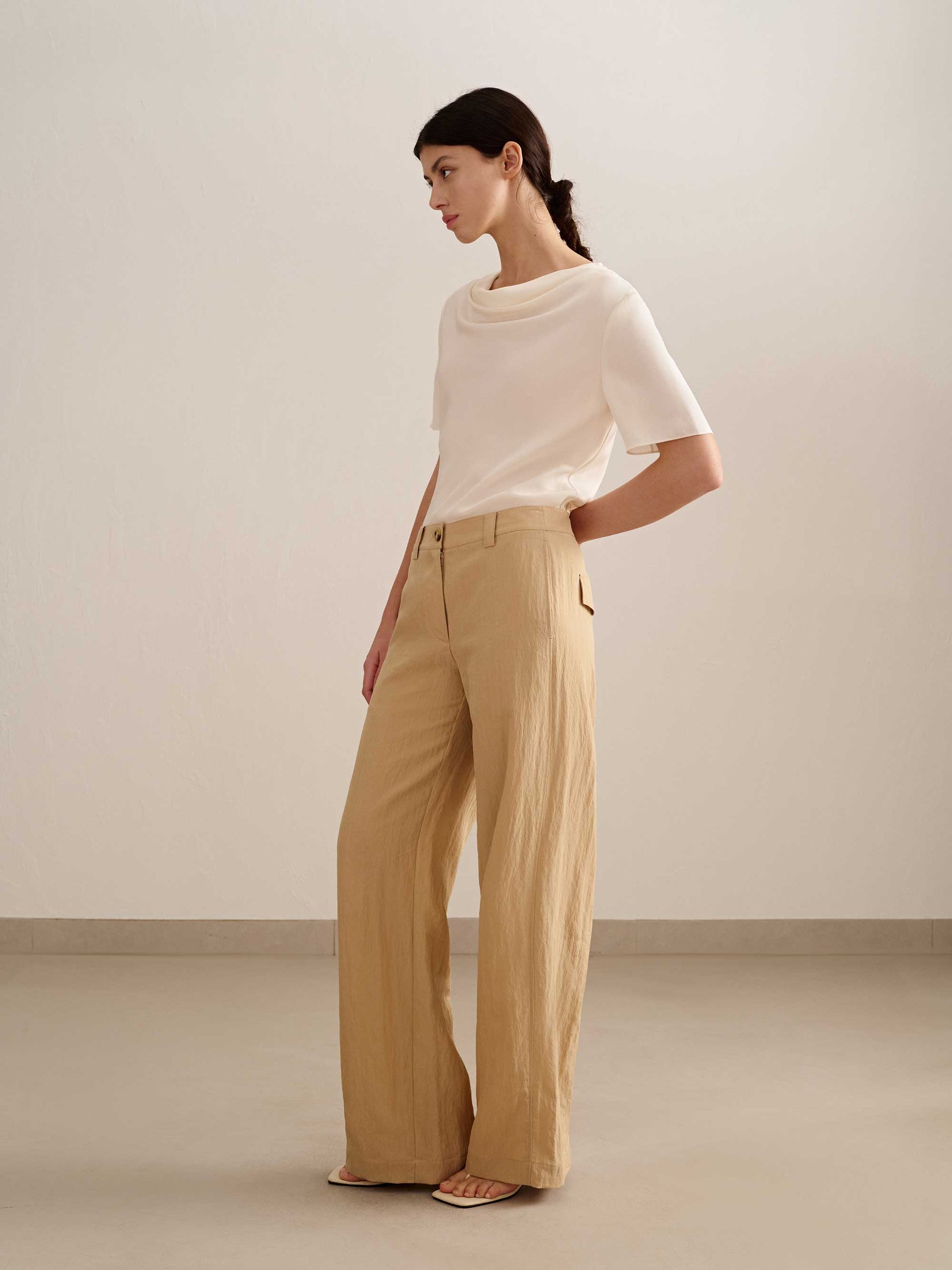 a woman wearing a yellow wide leg trousers with white tee