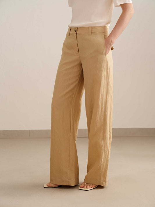 a woman wearing a yellow wide leg trousers with white tee