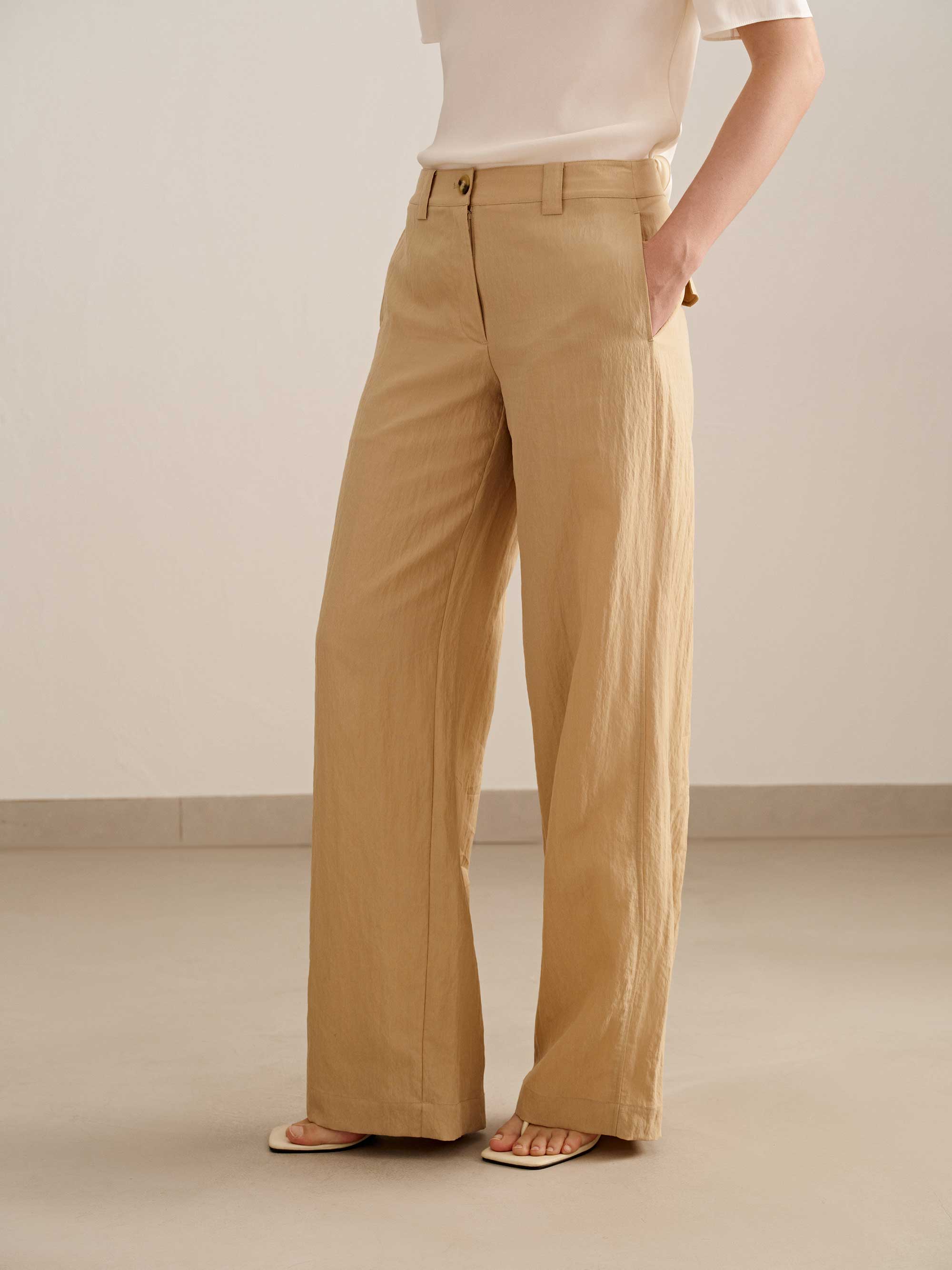 a woman wearing a yellow wide leg trousers with white tee