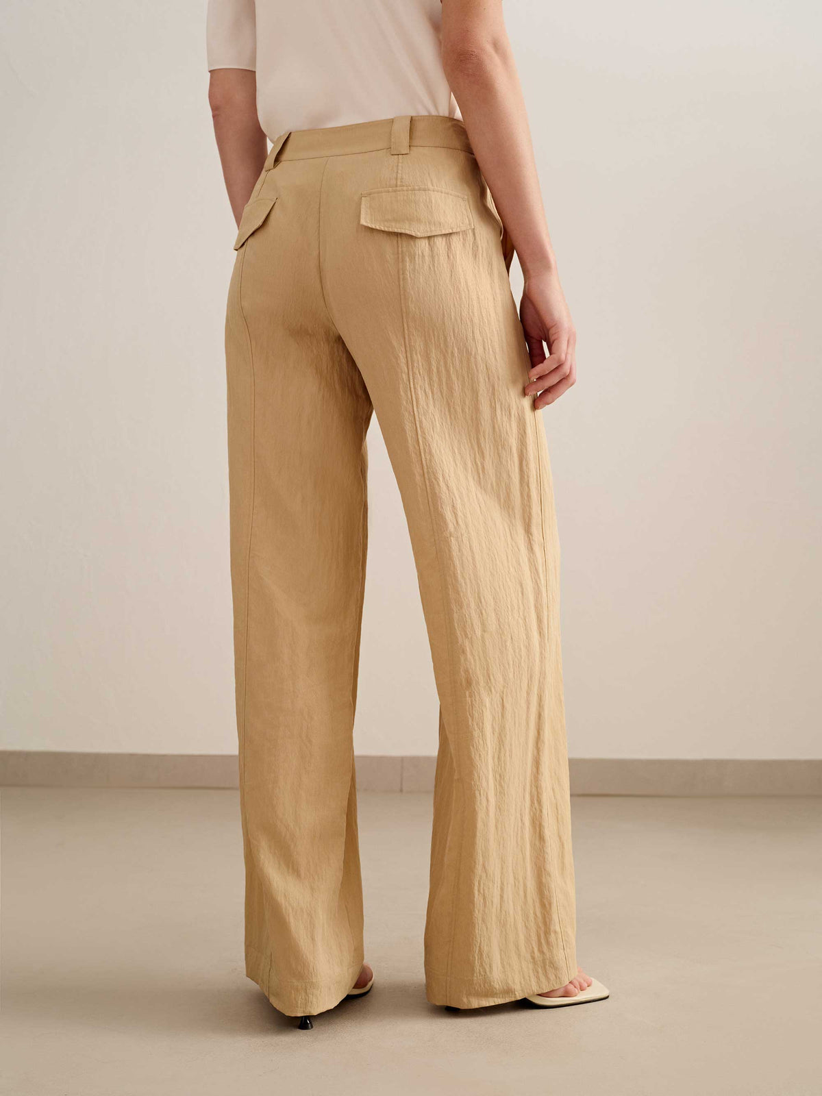 back of a woman wearing a yellow wide leg trousers with white tee