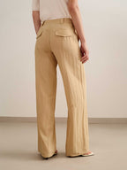 back of a woman wearing a yellow wide leg trousers with white tee