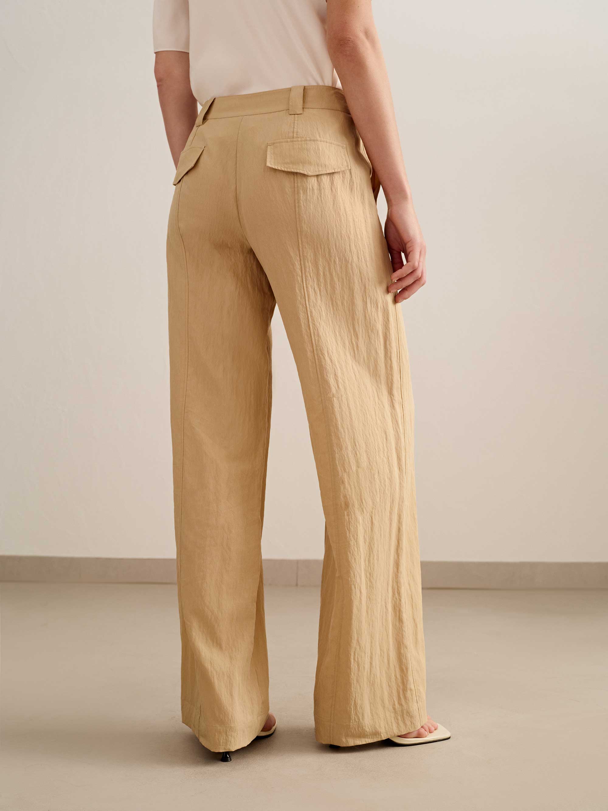 back of a woman wearing a yellow wide leg trousers with white tee