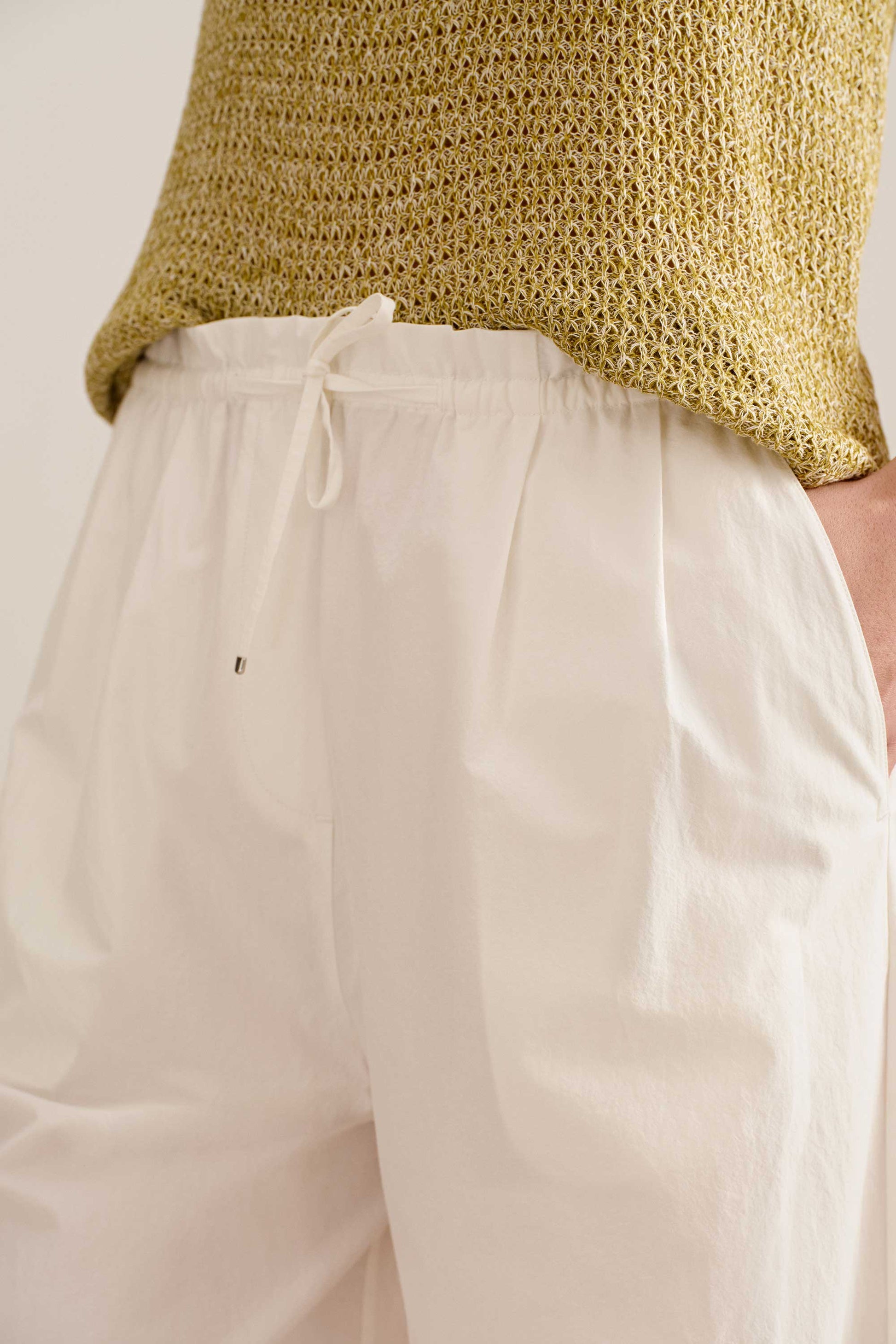 close up detail of a knot tying on the white wide leg pants.