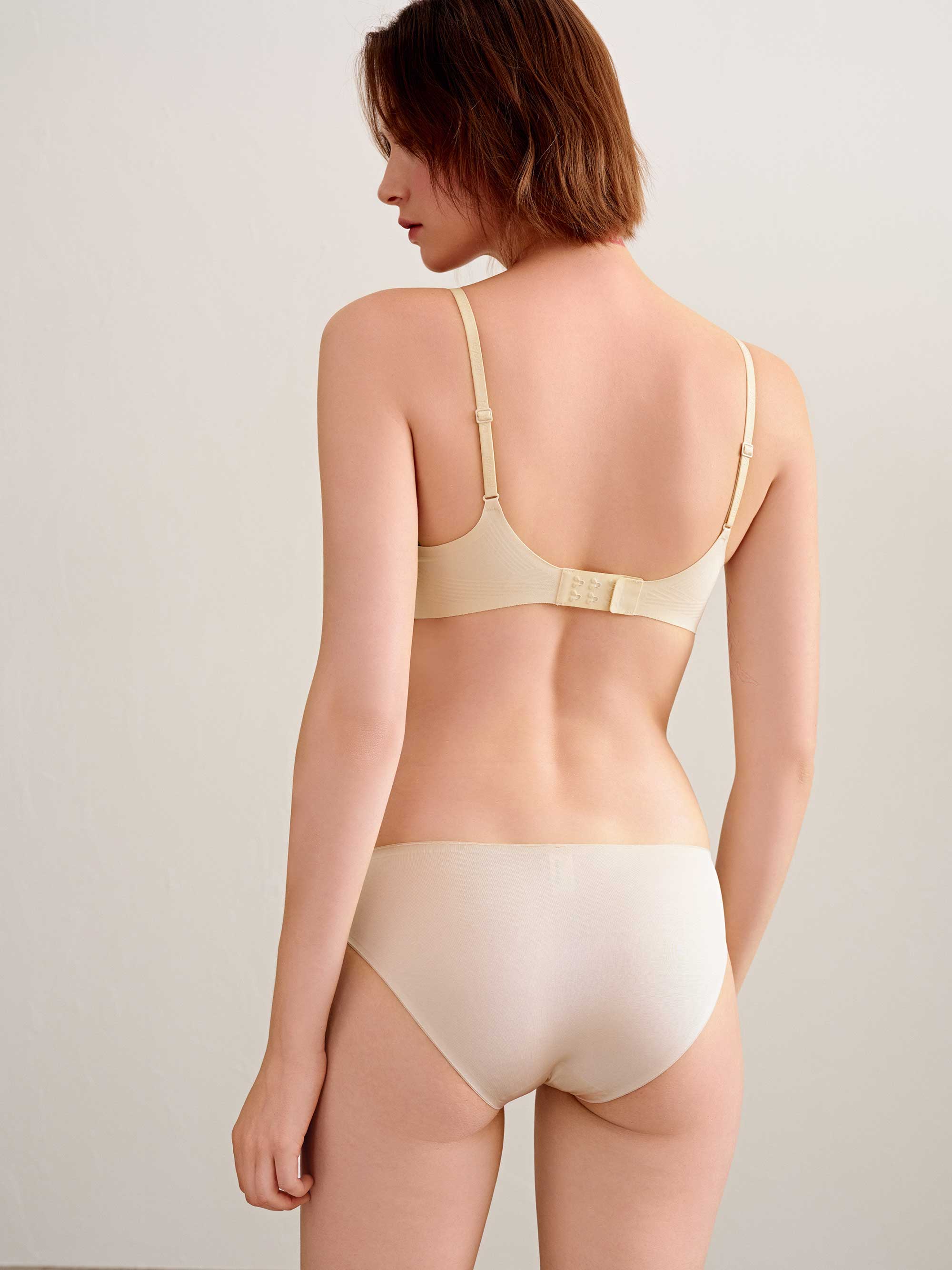 back of woman in cream bra and brief