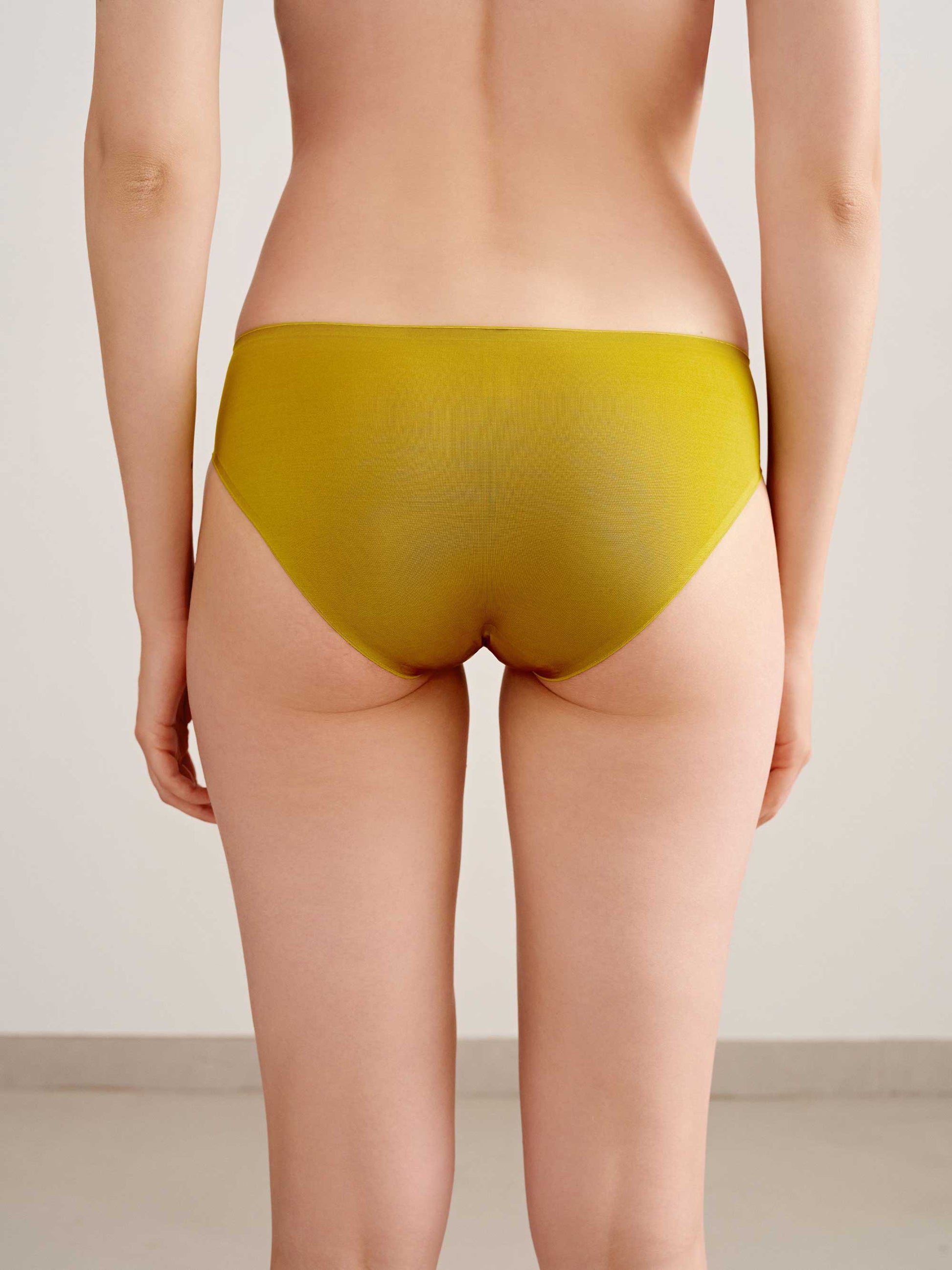 back of woman in mustard brief