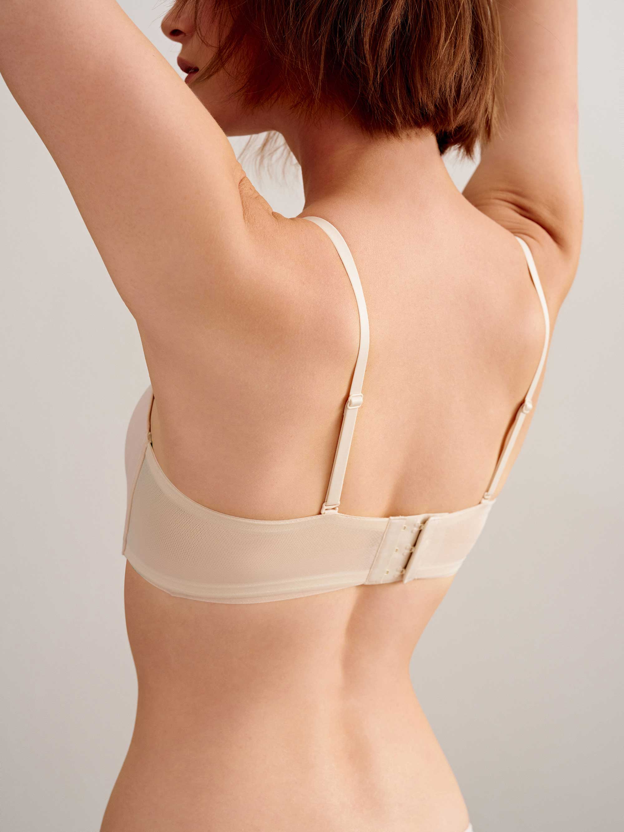 back of woman in off white bra