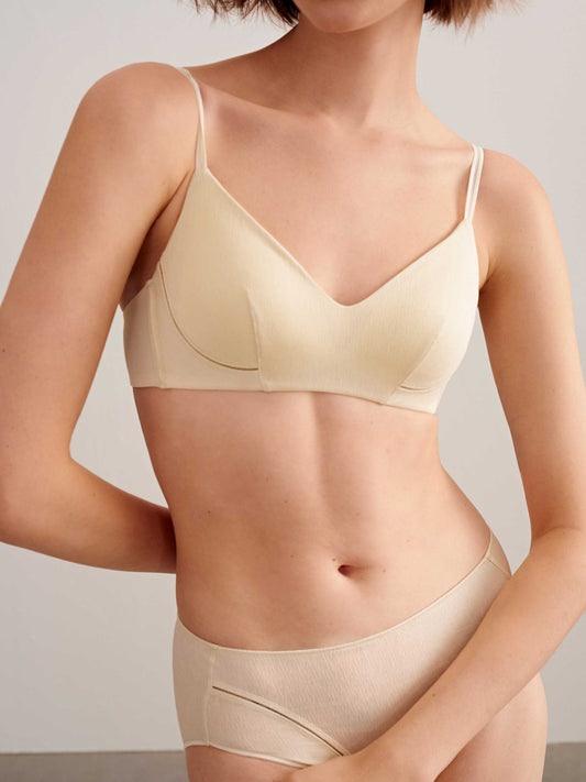 a woman wearing light beige bra and brief. 