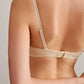 back of a woman wearing a light beige bra with clasp. 