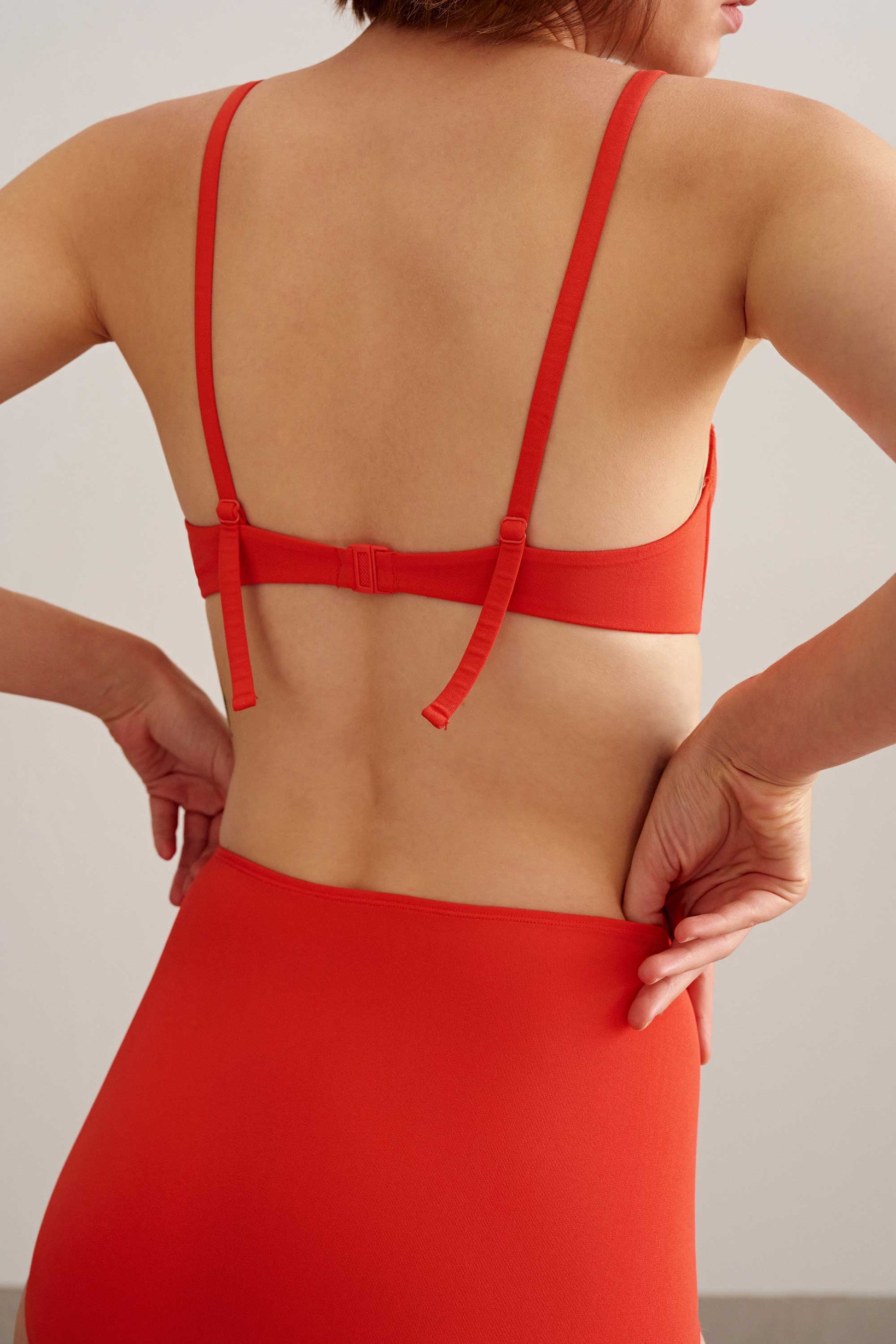 back of woman in orange bikini top and bottoms