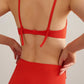 back of woman in orange bikini top and bottoms