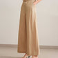 side look of a woman wearing a beige tank and light brown wide leg pants, pair with a white sandal. 
