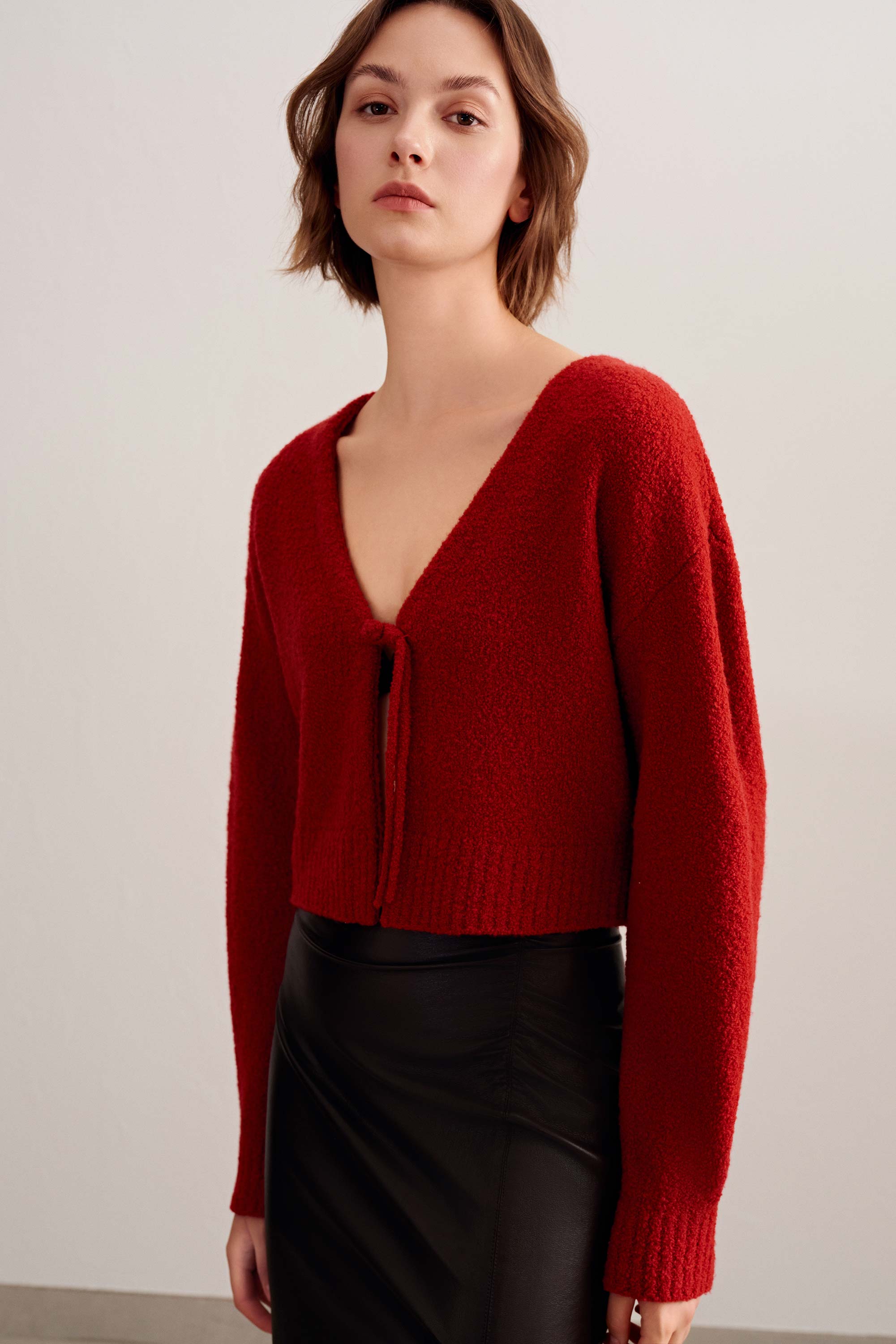 a woman wearing a red knot cardigan