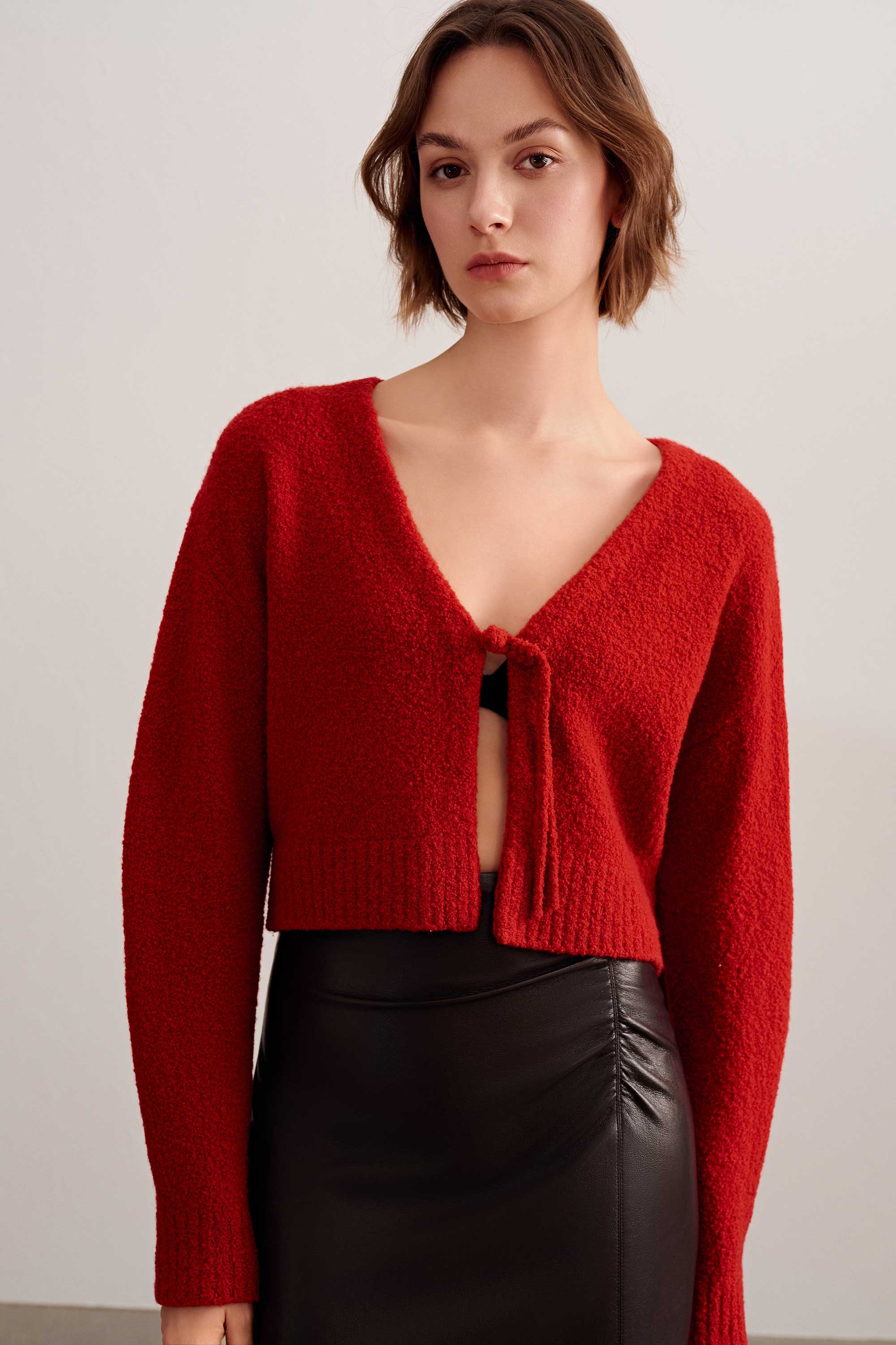 a woman wearing a red knot cardigan
