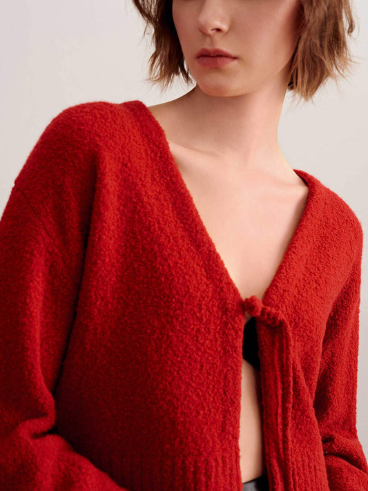 a woman wearing a red knot cardigan