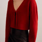 a woman wearing a red knot cardigan
