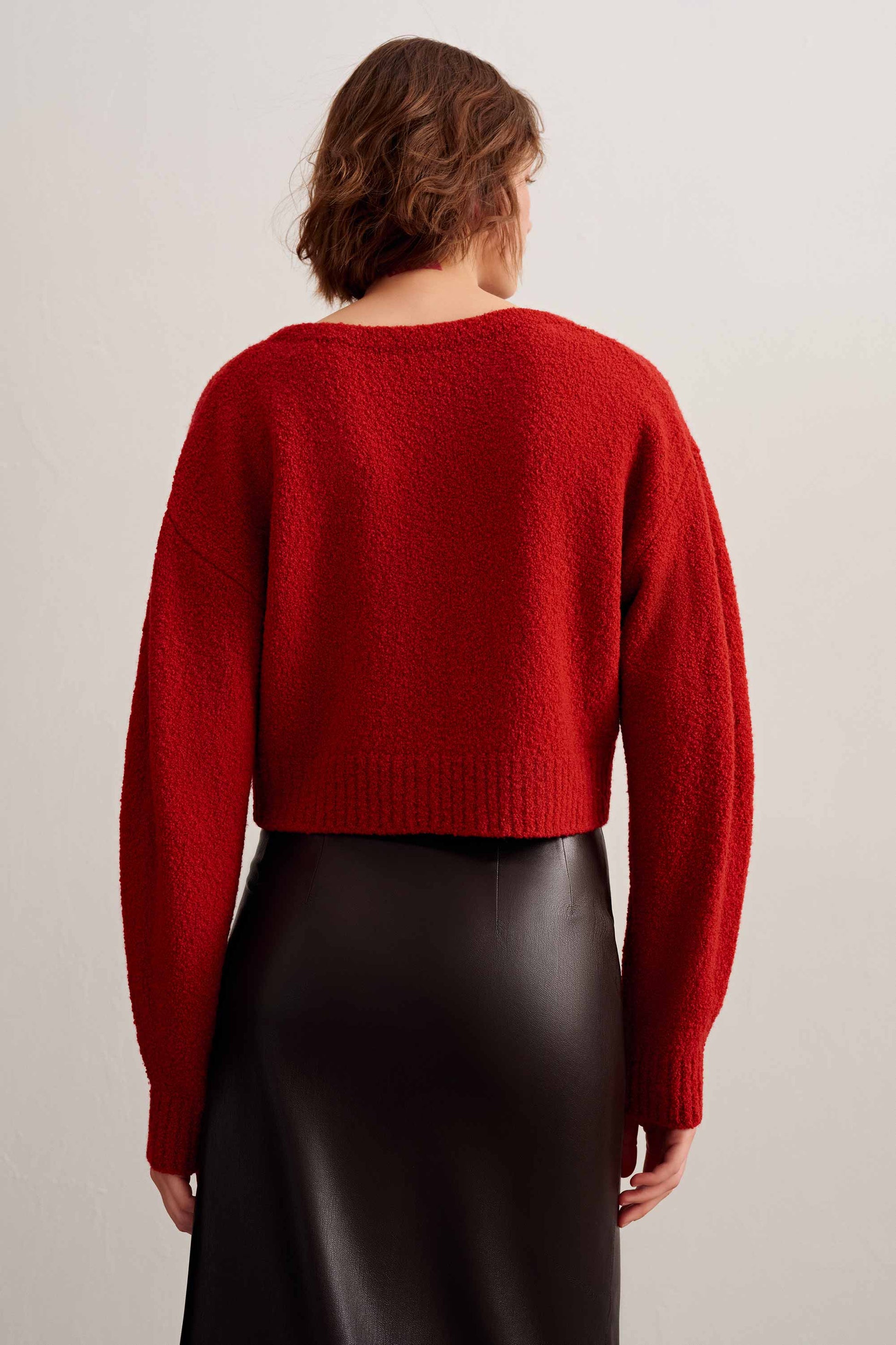 back of a woman wearing a red knot cardigan