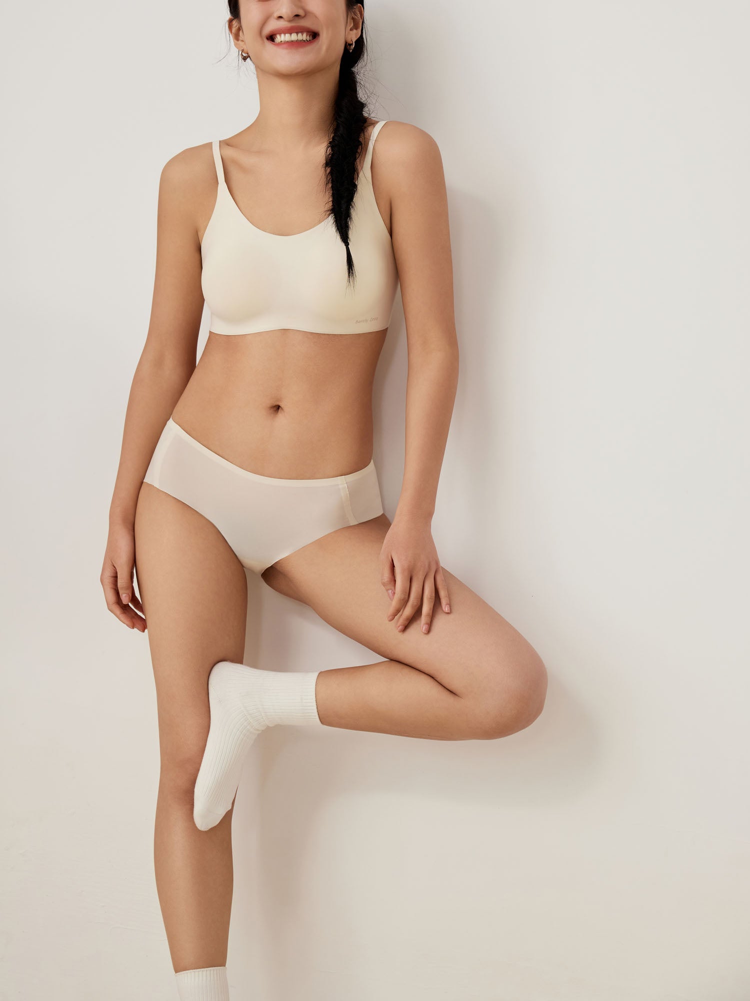 Model wearing white brief and bra set.