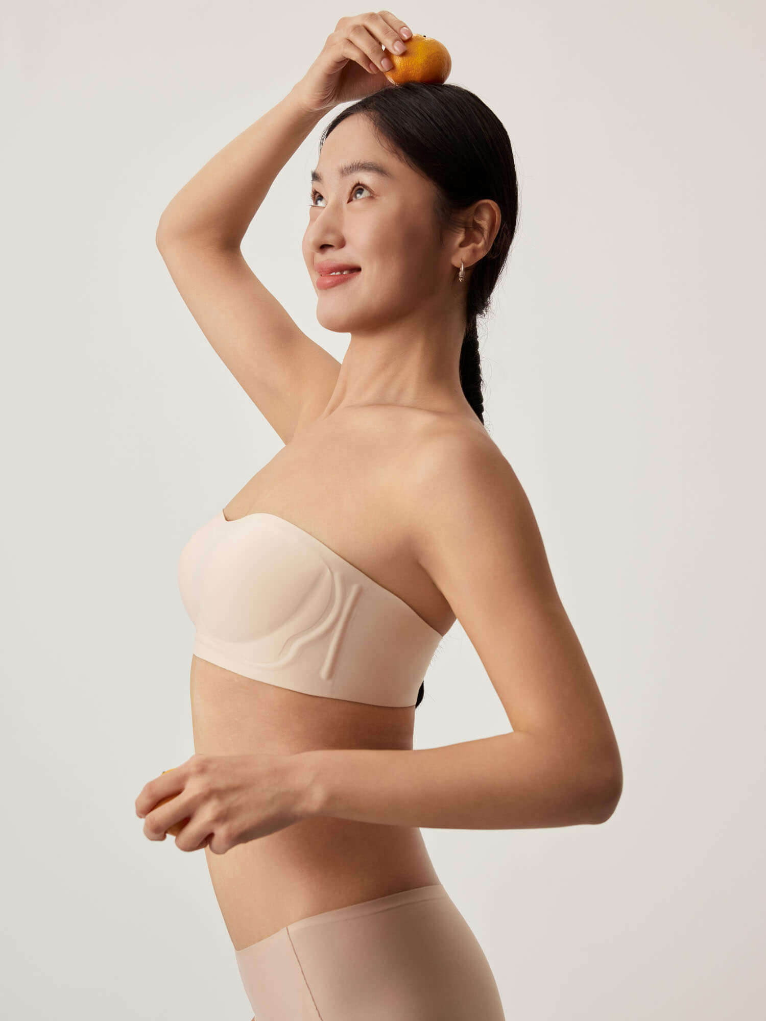 Side view of model wearing nude bandeau bra and briefs. Treacly Almond color. 