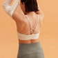 back of a woman wearing a white sports bra and grey skirt. 