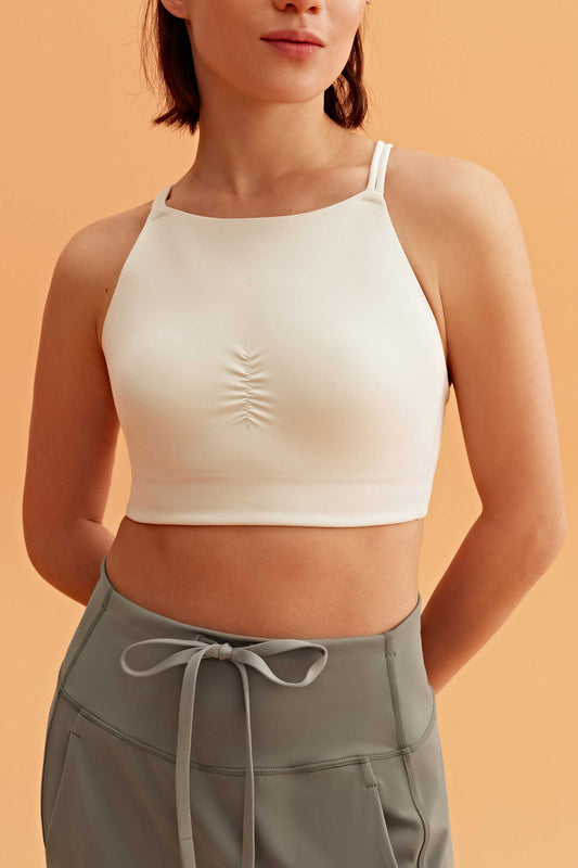 a woman wearing a white sports bra top and pants.