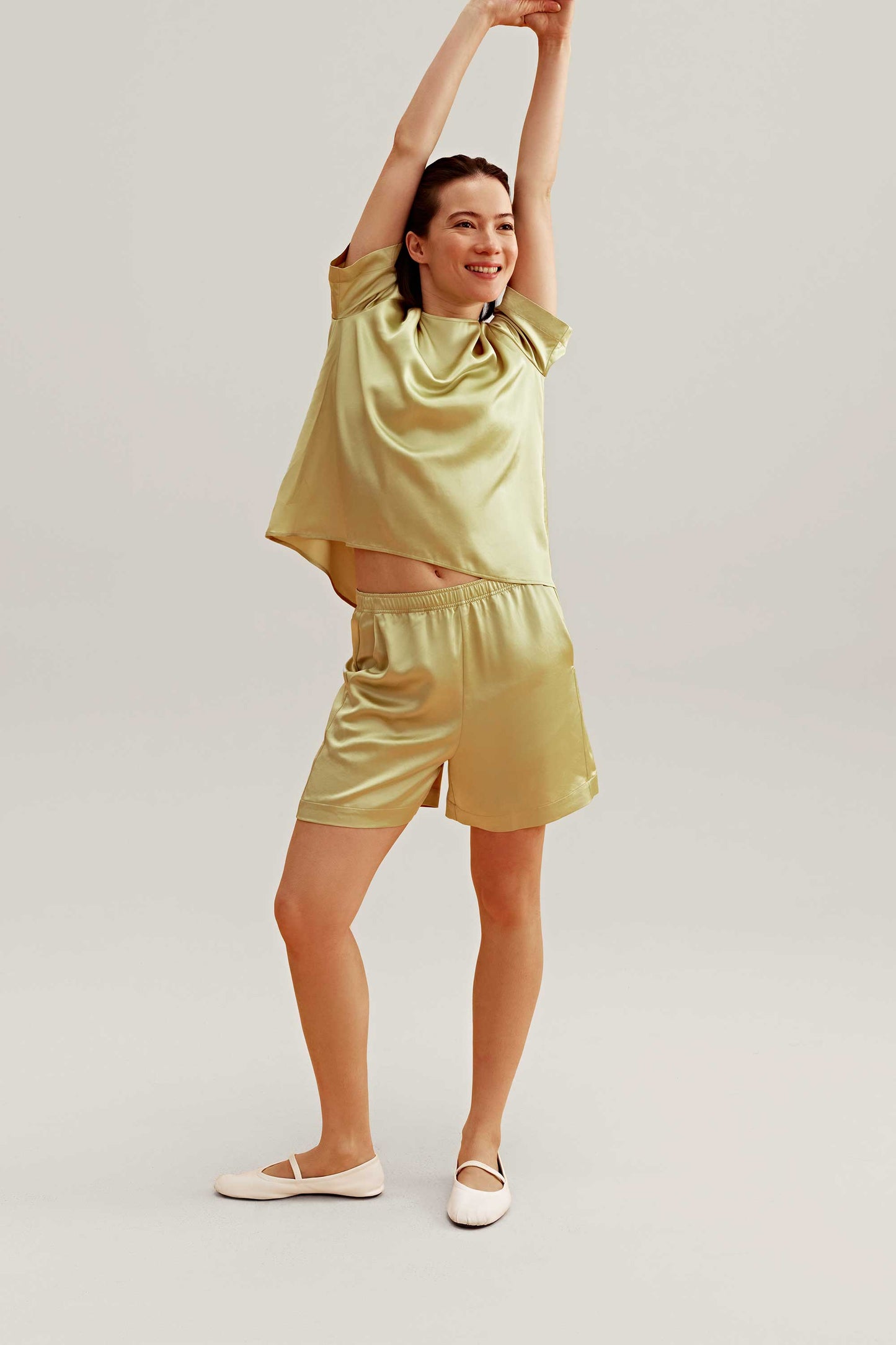 woman wearing a satin green short sleeve and shorts 