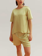 woman wearing a satin green short sleeve and shorts 