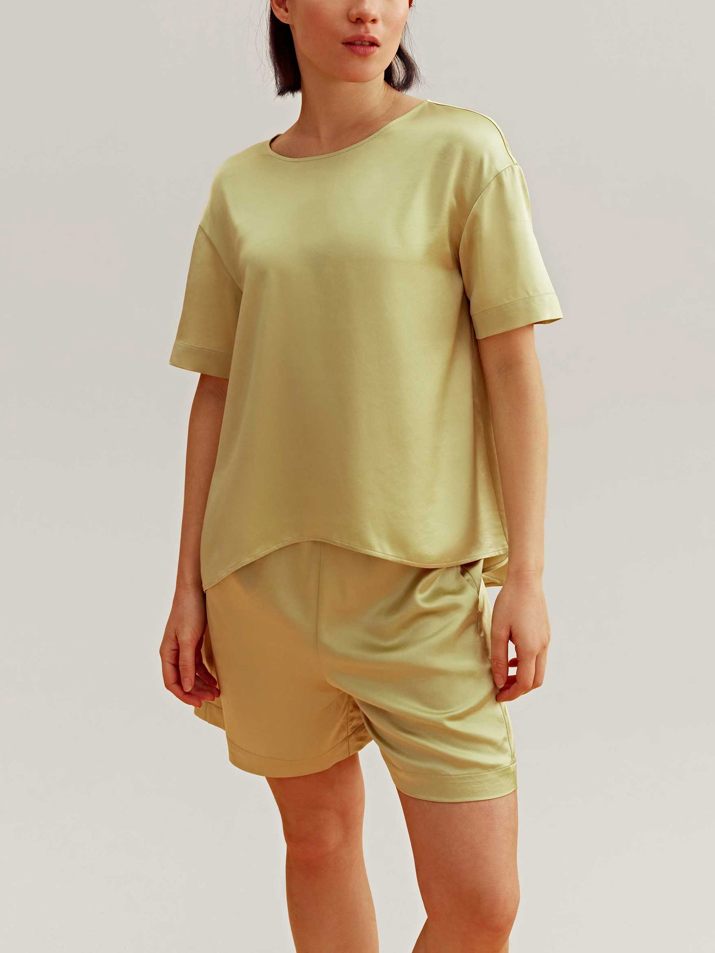 woman wearing a satin green short sleeve and shorts 